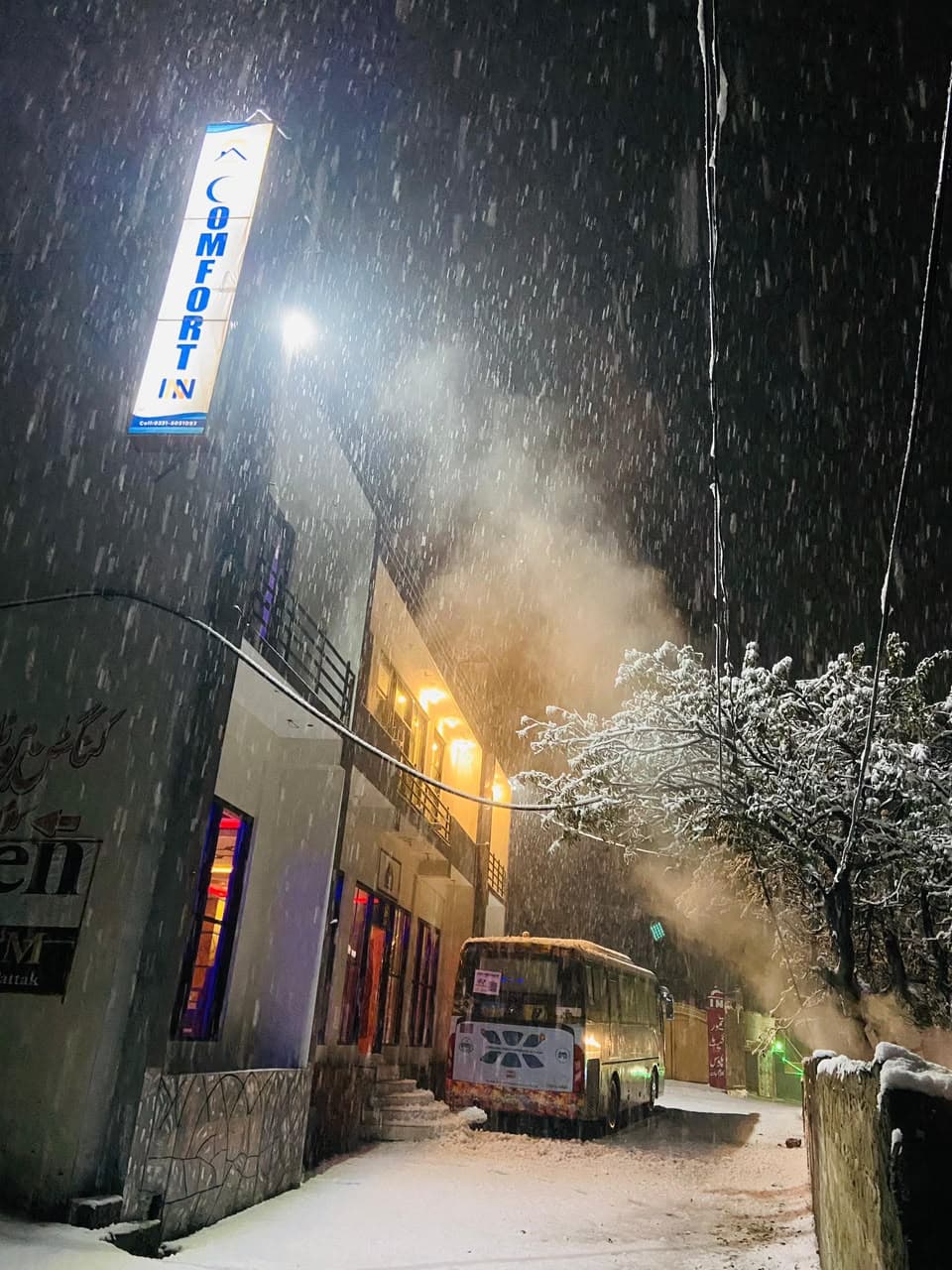 Comfort Inn Kalam signboard illuminated in the snow at night