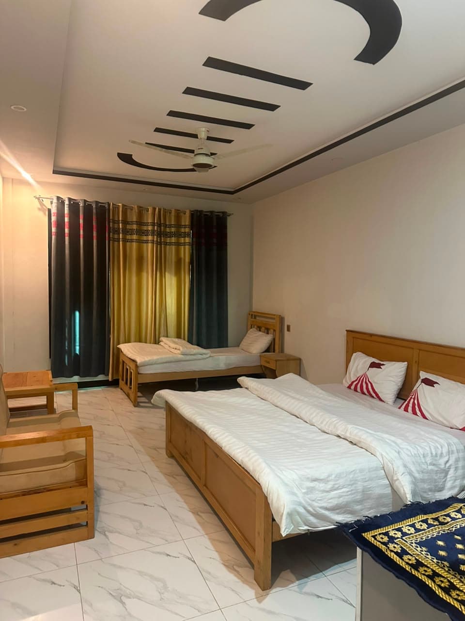 Spacious deluxe room with single and double beds at Comfort Inn Kalam